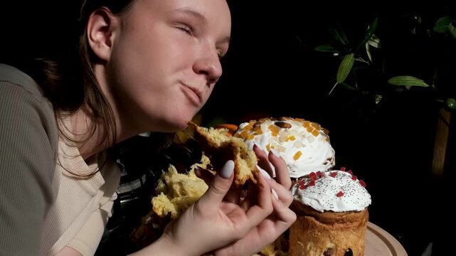 Soft Easter breads tasting moment as female hands tear and eat fluffy paska kulich and colomba enjoying fresh sweet crumb in cozy festive atmosphere