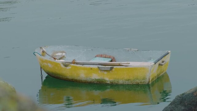 Weathered yellow dinghy in the mist