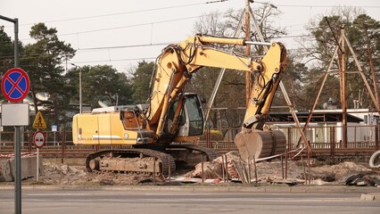Żółta koparko ładowarka z dużą łyżką. Prace budowlane z wykorzystaniem ciężkiego sprzętu.   © tomo81