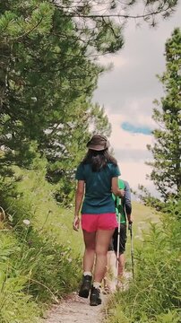Aerial pov couple hikes together along rugged trail toward the jagged Rossz&auml;hne peaks in the Italian Dolomites. Majestic limestone peaks. UNESCO World Heritage scene. Gardena pass lope hiking trail