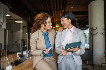 Obraz premium Diverse business women collaborating and smiling in office