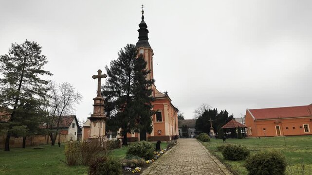 Church building with cobblestone pathway leading to entrance in Senta Serbia, creating perspective and symbolizing spiritual journey and calm atmosphere