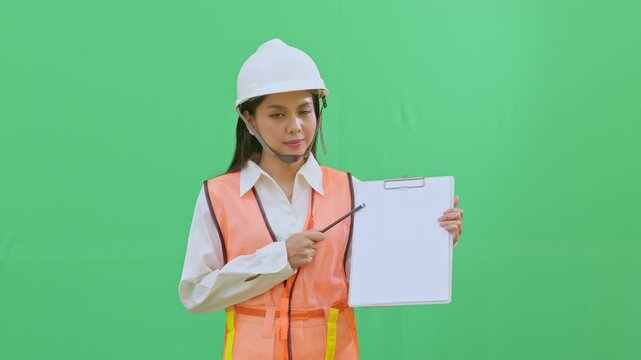 A female supervisor pointing at a specific data point on her clipboard. Highlighting safety issues or technical details during a site review on green screen.