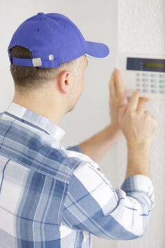 handsome young electrician repairing intercom