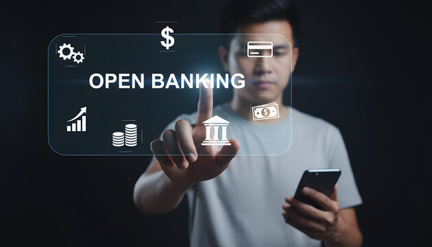 Young man interacts with a glowing virtual Open Banking screen displaying financial icons holding a smartphone representing modern secure digital fina