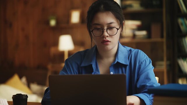 Young Korean female writer having problems with laptop, facing data loss