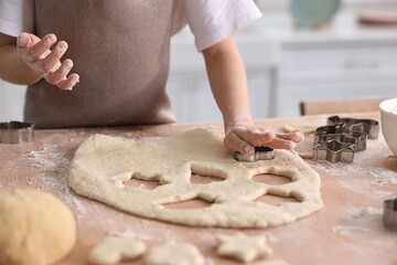 Child cutting cookies at table indoors, closeup © New Africa