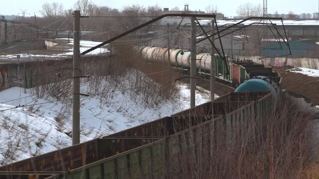 Snowcovered Railway With Freight Cars Moving Slowly Near Rusted Fences And Leafless Shrubs . Media