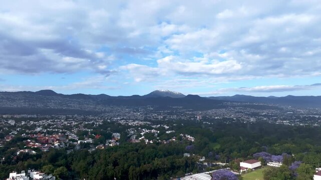 Urban Landscape of Mexico City, Tlalpan  with Snowy Ajusco Mountain and Blooming Jacarandas 4K