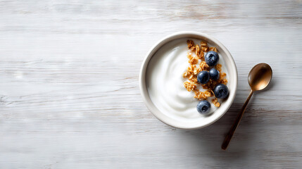 Fototapeta premium Fresh Yogurt Bowl with Granola and Blueberries on Wooden Surface