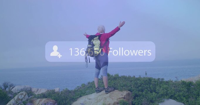 Hiker on rock raising arms, social followers fading in over frame and climbing, showing growth