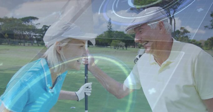 Woman holding flagstick on golf green, man reaching causing HUD rings marking hole while laughing