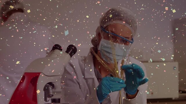 Lab tech picking up sample and inspecting at microscope for analysis, particles drifting foreground