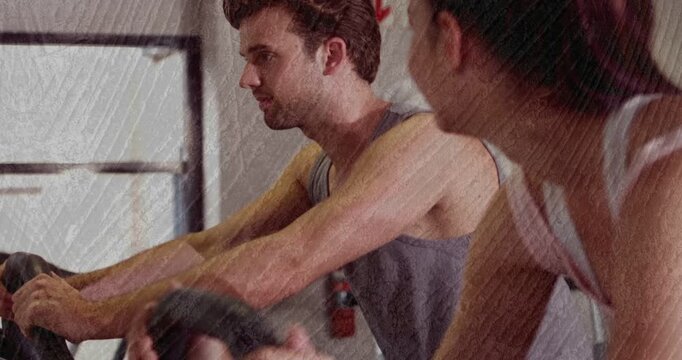 Woman gripping bars pedaling on spin bikes in gym, man turning head smiling, sparking exchange