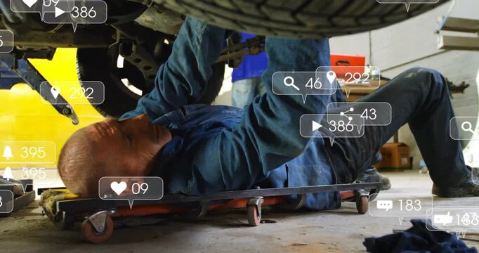 Mechanic lying on creeper torquing bolts for repair, with views rising, alerts appearing over wheel