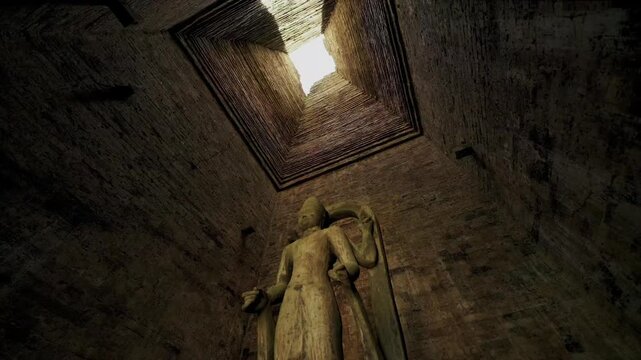 Low angle view of a stone deity inside a dark brick temple tower with a hole in the ceiling