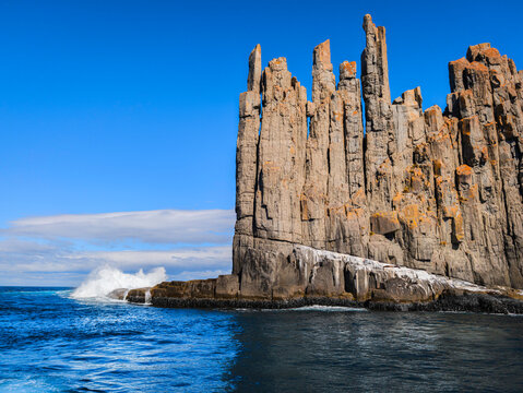 Cape Raoul seascape with rock platforms, towering cliffs, columns, blue sky, and the Tasman Sea in Tasmania, Australia