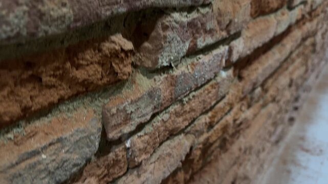 Close-up crumbling rustic aged brick wall rough texture background detail