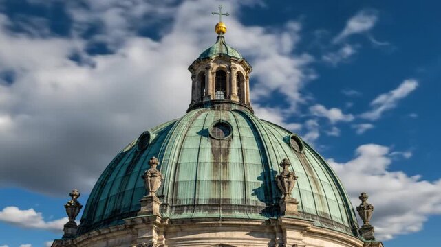 Ancient church dome with copper roof against a deep blue sky with fluffy white clouds, architectural details.