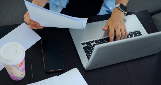 Paper exchange quickly. Fastpaced business interaction involving documents and digital devices. Swift document transfer between colleagues amid coffee and technology in professional setting