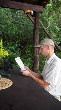An ornithologist identifying bird species at a jungle lodge