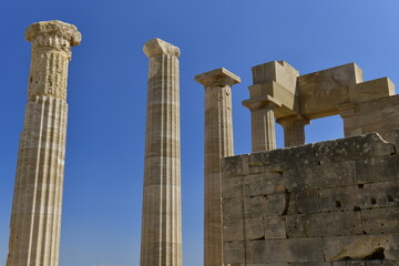 Lindos Acropolis, Lindos, Rhodes Island, Greece. The tall column and cornice of an archeological Roman-Greek temple site of Athena from the 4th century BC in Spring. © alagz