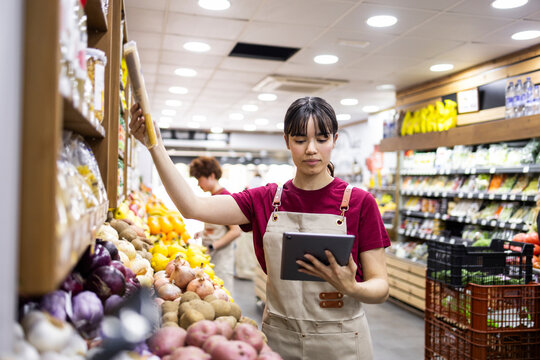 Shop assistant managing inventory in fruit store