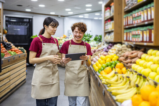 Fruit section in a grocery with shop assistants