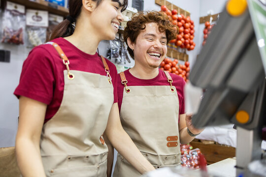Shop assistants smiling at fruit store counter