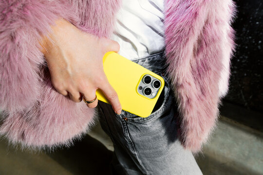 Fashionable Gen Z woman with phone in urban setting