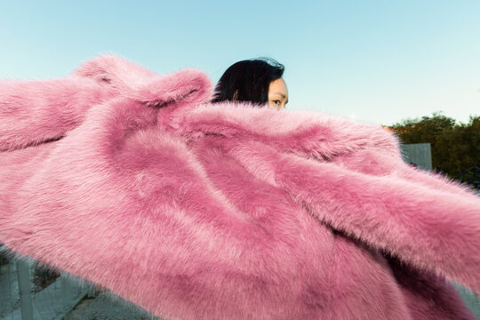 Stylish portrait of asian woman in pink fur coat
