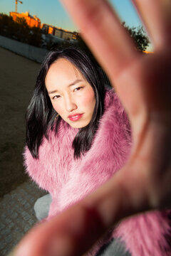 Asian woman in urban setting with pink fur coat