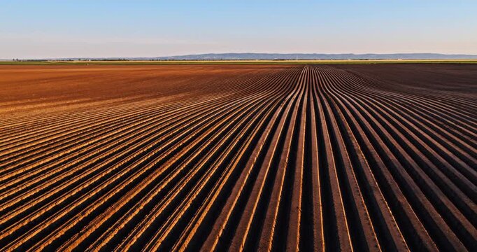 Aerial view flying over plowed agricultural field