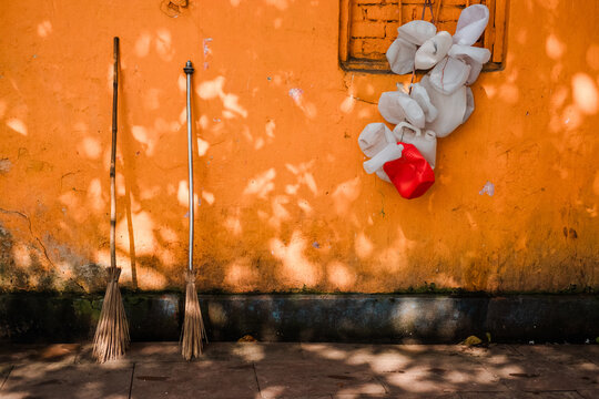 Brooms and canisters against a vibrant wall