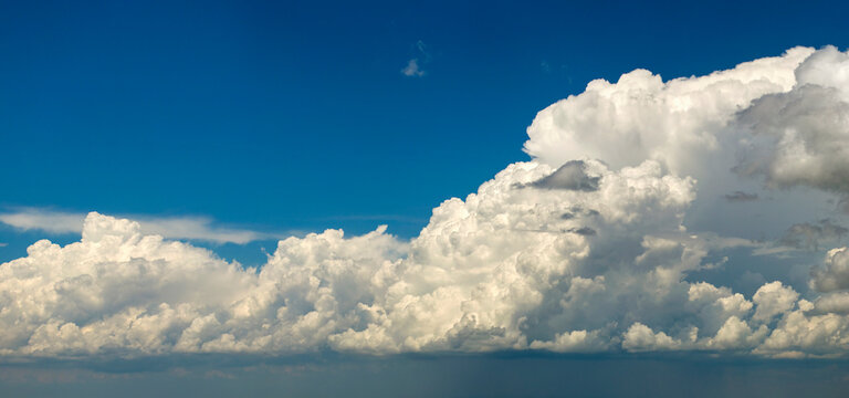 Bright landscape of blue sky with flying white clouds. Colorful summer skyscape