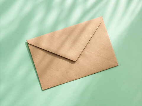 Kraft Paper Envelope Flat Lay on Mint Green Background with Soft Natural Shadow