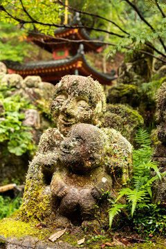 close-up view of stone statue covered in moss and plants at Otagi Nenbutsu-ji Temple in Arashiyama, Kyoto, Japan