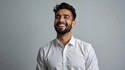 Obraz premium Portrait of handsome smiling young man looking up. Laughing joyful cheerful men studio shot. Isolated on gray background. Arabic style. Muslim businessman. 