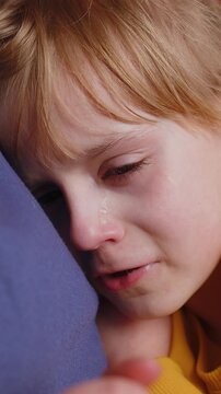 Close-up portrait of upset child little girl kid crying with tears flowing down on her cheek, toddler lies on mother at home. Mom hugs, embrace, takes pity on her daughter. Quarrel bullying at school.