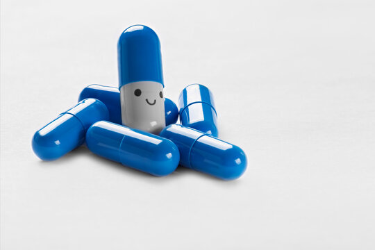 Blue smiling pills close-up on white background.
