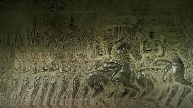 Light moving over ancient bas relief carvings of Khmer army at Angkor Wat temple in Cambodia