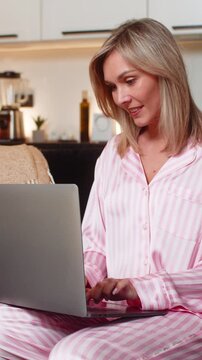 Adult woman at night home opens laptop starts sprint types fast updates project board smiles focused. Caucasian girl on sofa at evening marks to do done checks checklist ticks boxes enjoys progress