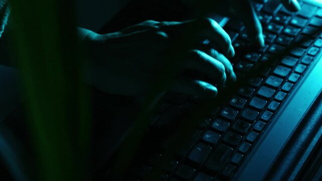 Business woman typing the fingers on keyboard. Laptop placed on a desk in dark work space. Low key shadow with blue color art lighting. Closeup series of videos from different angles