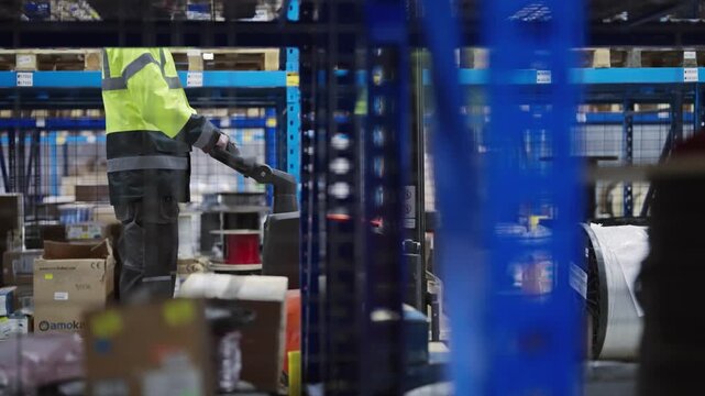 Worker drive electric forklift equipment in a modern industrial warehouse environment