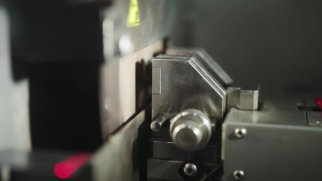 View of advanced machinery in a cable production facility demonstrating a precise cable cutting process with industrial focus and high precision tools
