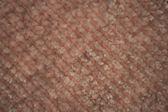 macro texture of soft pink plush fabric. Close-up of cozy textile with delicate fibers and warm pastel tones. Smooth, soft surface creates a calm and comfortable background perfect for fashion, home d