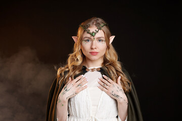 Obraz premium Beautiful elf girl on black background with smoke