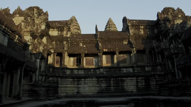 Ancient stone bas reliefs and ruins of the Angkor Wat temple in Cambodia at sunset