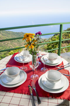Outdoor table set for dining with mountain and ocean view