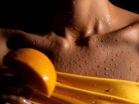 A close-up of a person's torso with water droplets and a yellow object